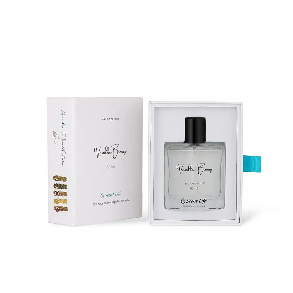 The Vanilla Breeze eau de parfum from Scent Life comes in a perfume box featuring a minimalist design with black text and a blue accent tab. The clear bottle is elegantly topped with a black cap and adorned with a simple script label, perfectly embodying the essence of this exquisite fragrance.