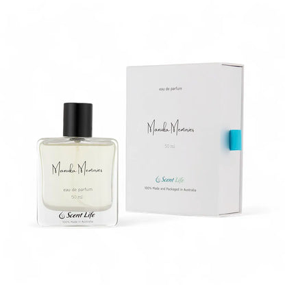 A 50 ml bottle of Scent Life's Manuka Memories eau de parfum, infused with honeyed sweetness, is elegantly positioned in front of its box. The clear bottle with a black cap complements the minimalist white design and soothing blue accents of the packaging.